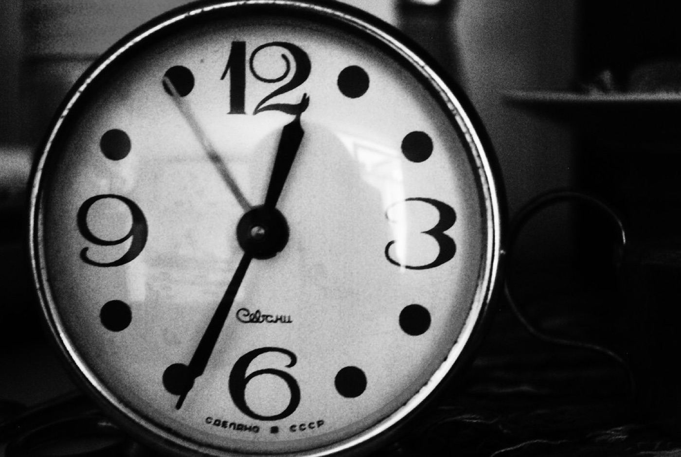 A bedside clock showing 1:11 glowing softly in a dark room.