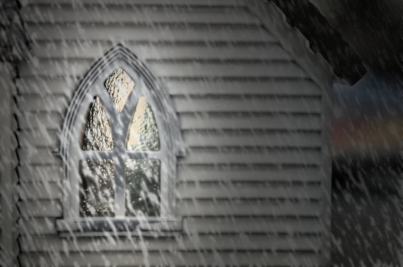 Sunlight streaming through a tall church window onto wooden pews.