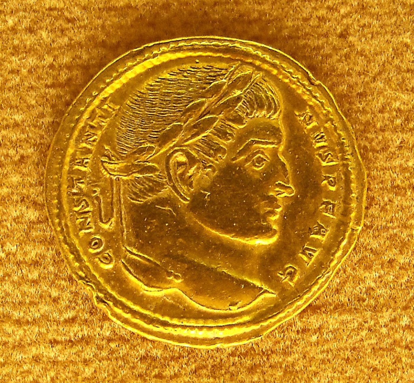 Gold coins catching warm light on a dark surface.