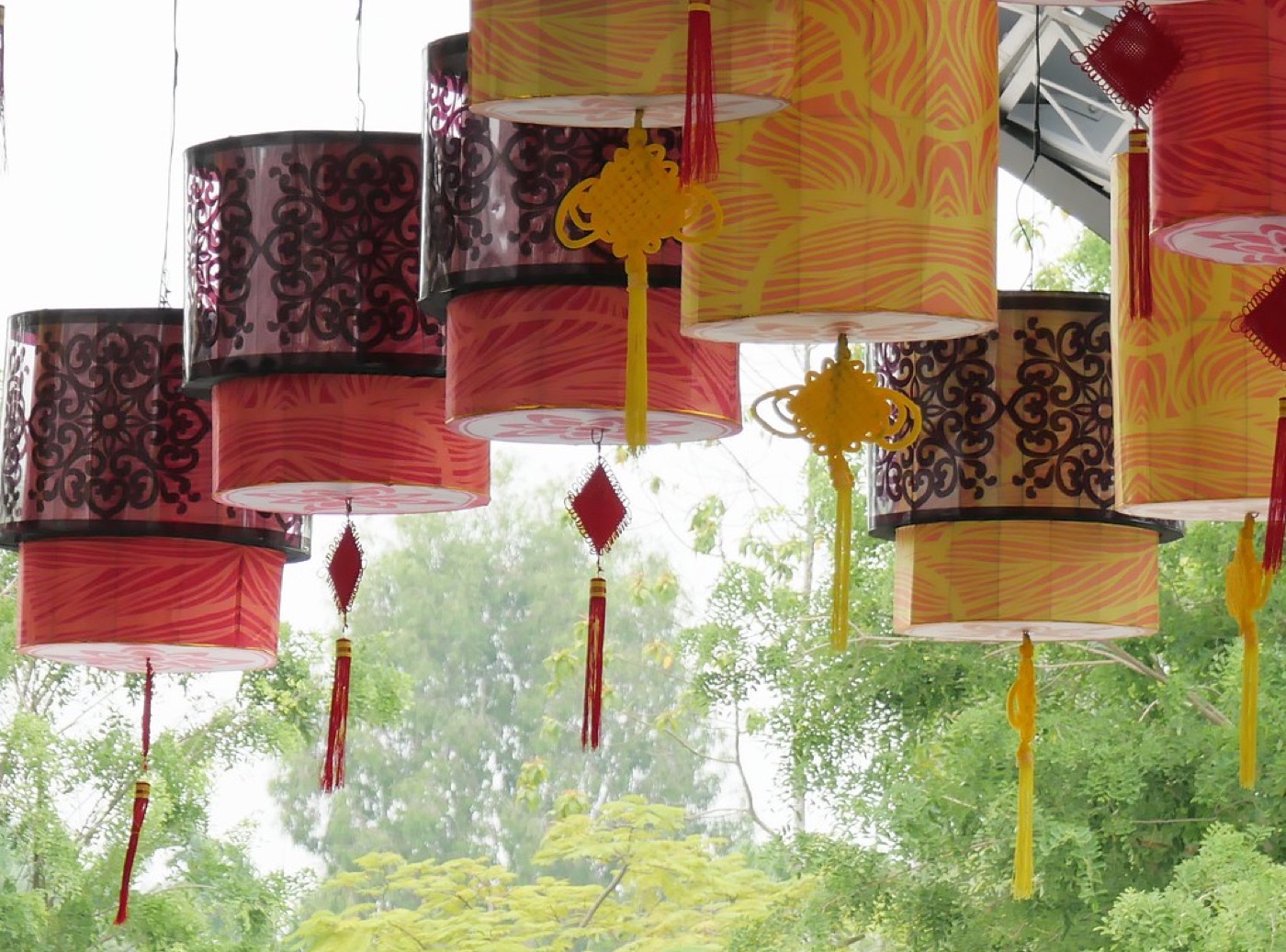 Rows of glowing red paper lanterns strung above a night-time street festival.